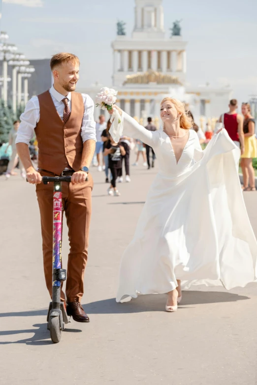 bride and groom on a motorized scooter holding hands