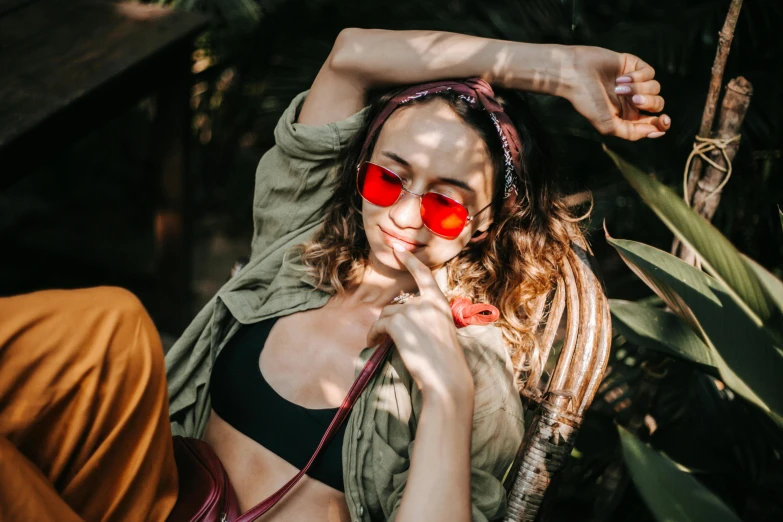 a beautiful young woman wearing red sunglasses and posing for a picture