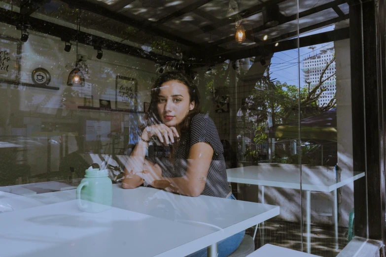 a woman is sitting at a table and smiling