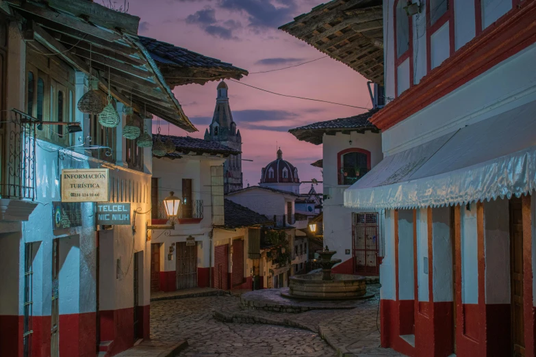 a street with buildings in the background with flags on each side