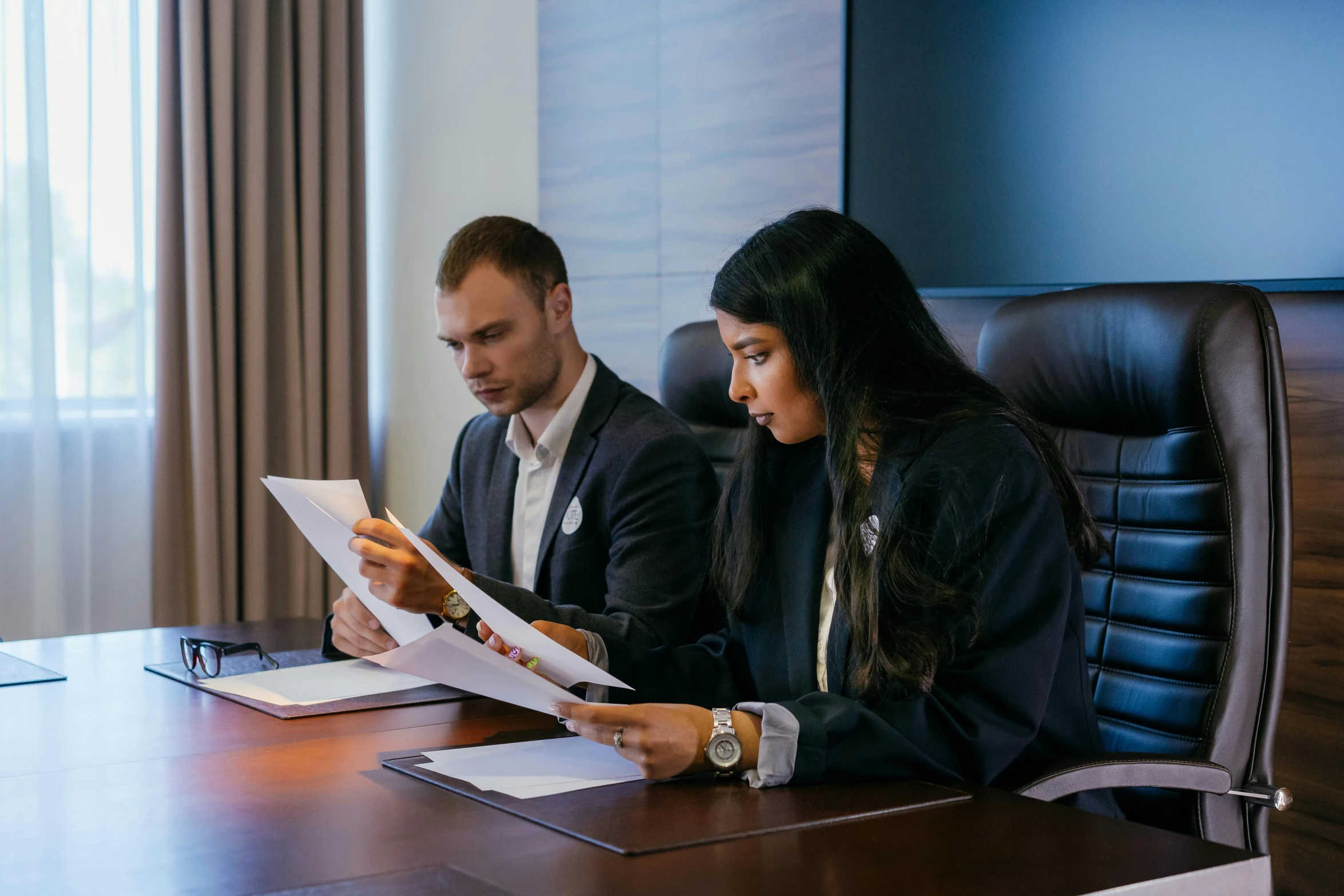 two people sitting at a table looking at paperwork