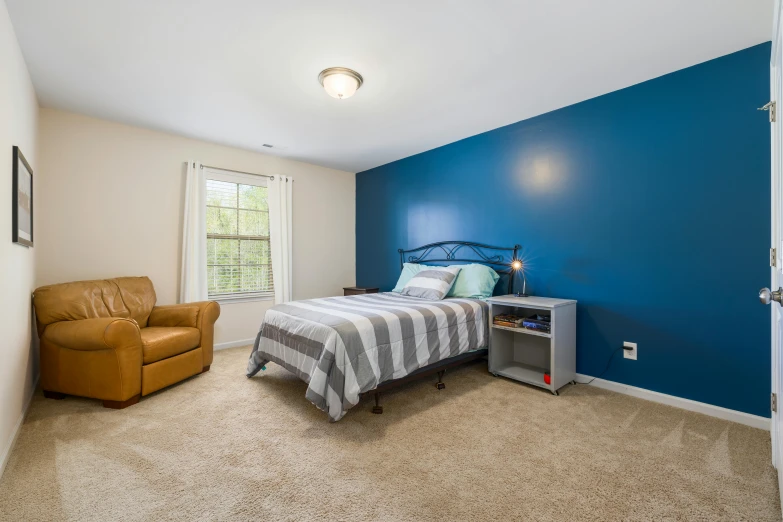 the small room has a blue wall and white furniture