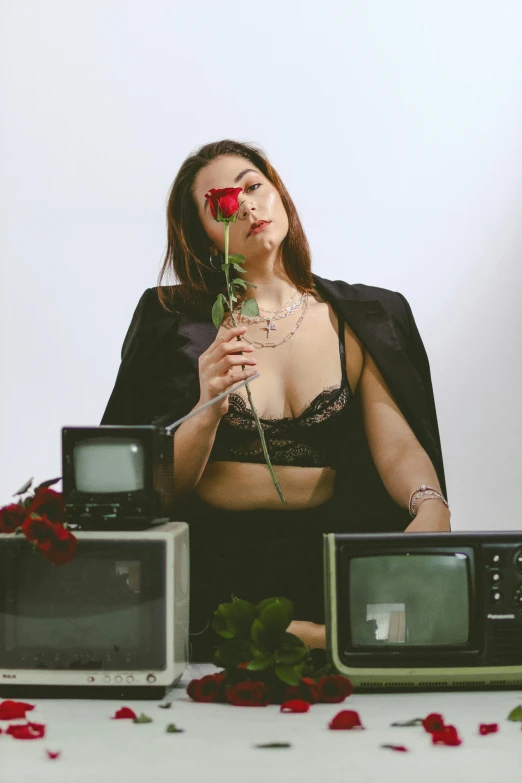 a woman in lingerie next to two old tvs