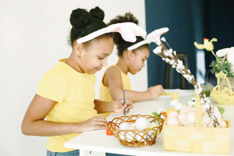 two children with bunny ears writing on paper