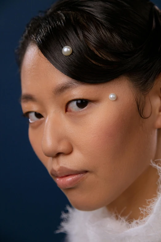 an asian lady wearing pearls with hair on top