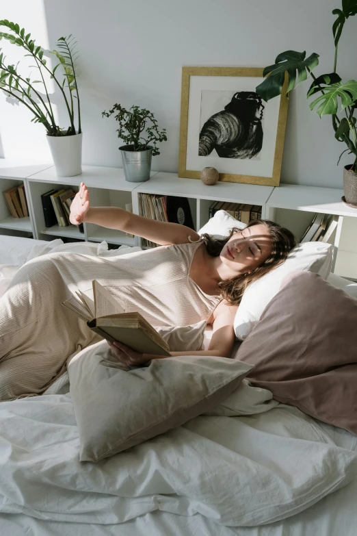 a woman is in bed reading a book