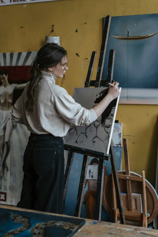 woman painting on canvass in a studio by herself