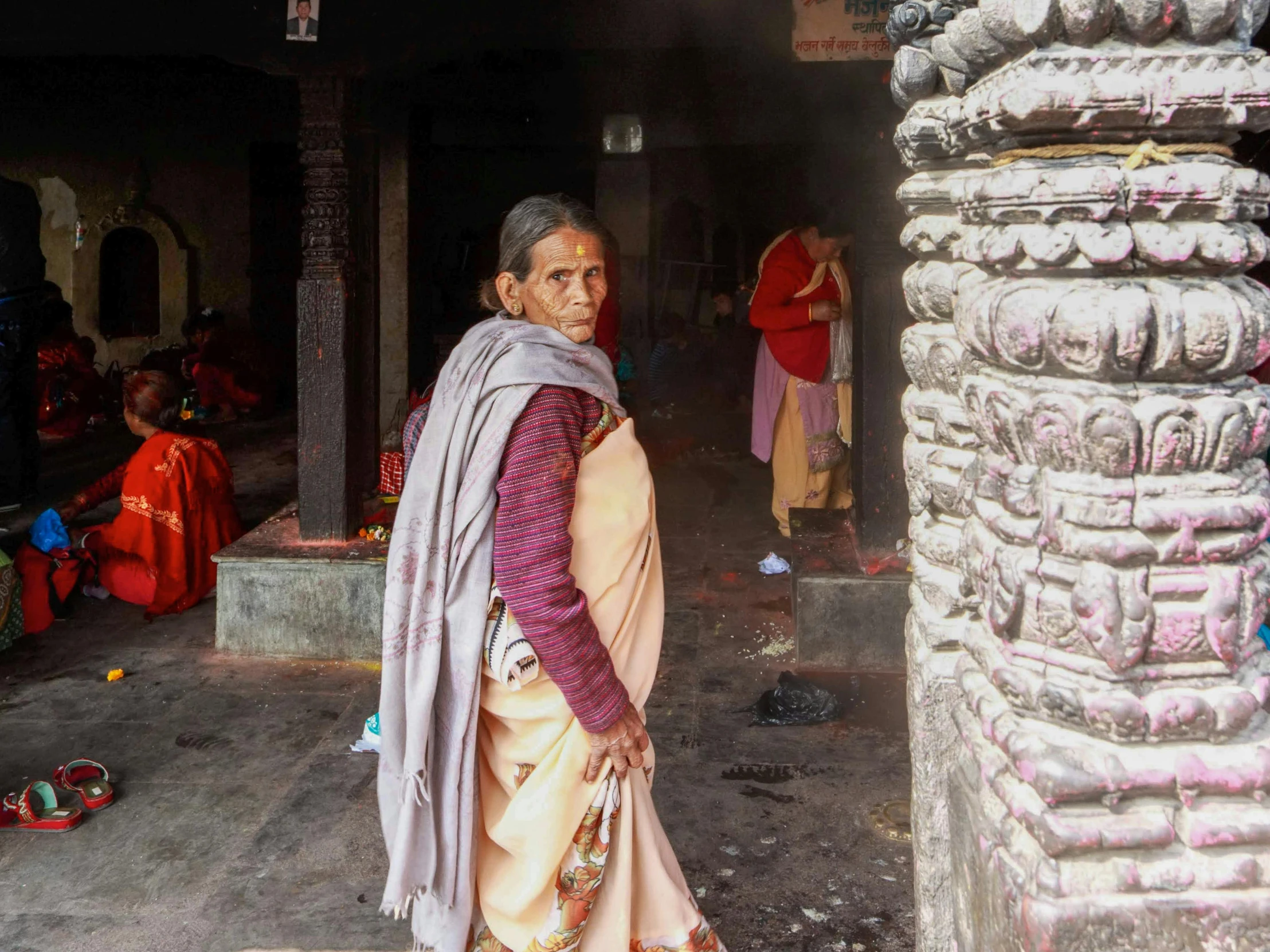 a person in a pink outfit near some pillars