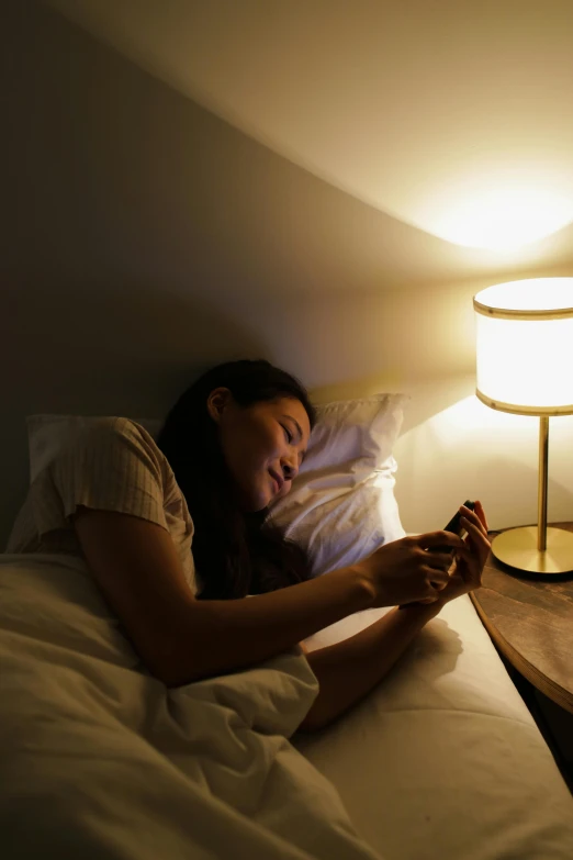 a girl laying in bed with a light on