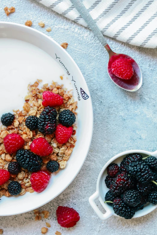 a cereal with berries on top and yogurt and syrup