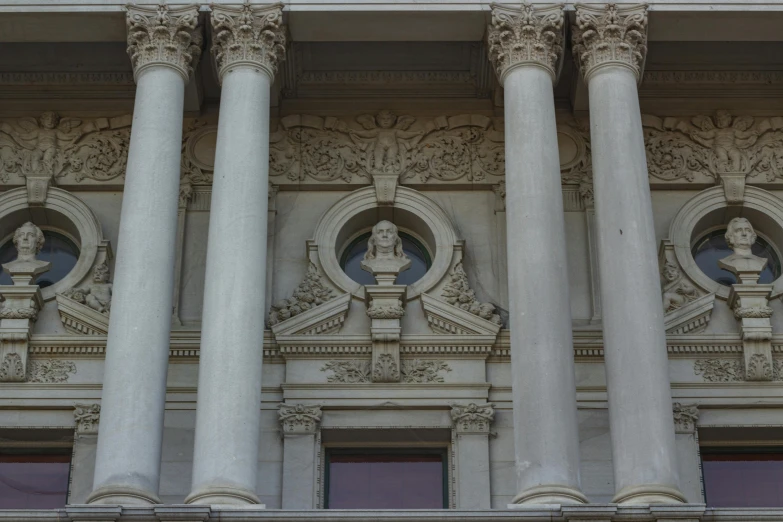 three white pillars with decorative detailing, on top of a building