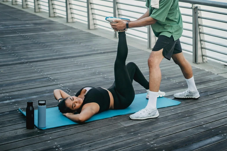 a woman standing on a mat next to a man working on her legs