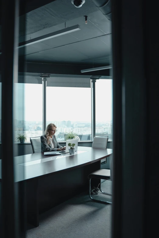 a woman is working at a table with an open laptop