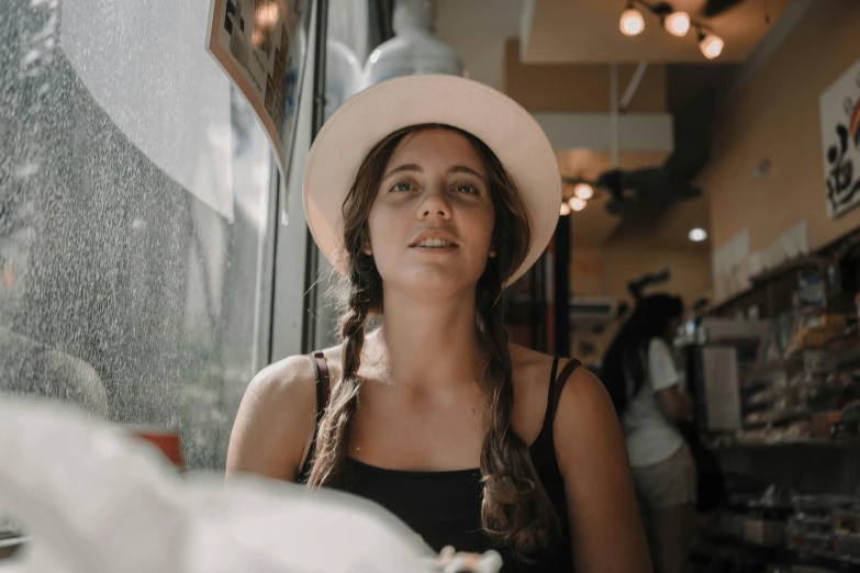 a woman with a white hat staring at the sky