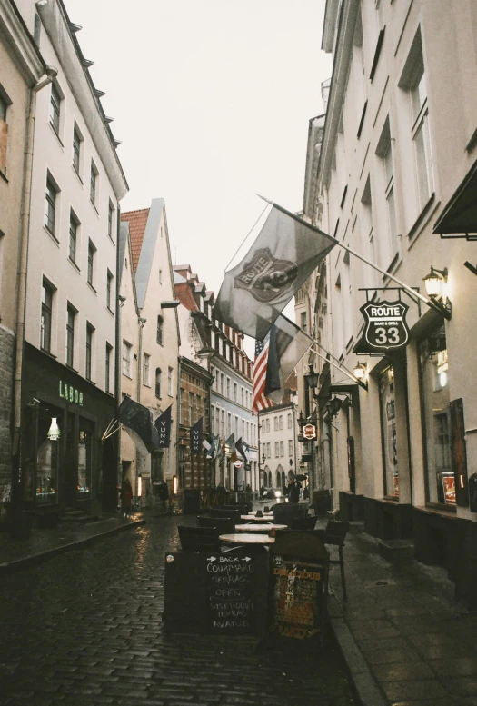 a narrow street lined with buildings and an american flag