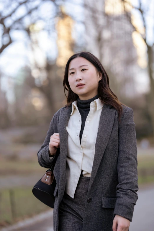 a woman in business clothes walking along a path