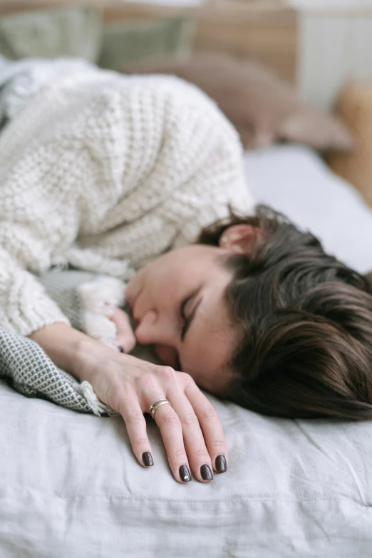 a woman with her hands on a pillow with a cat