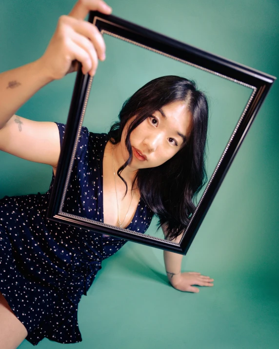 a girl posing with a picture frame in her hands