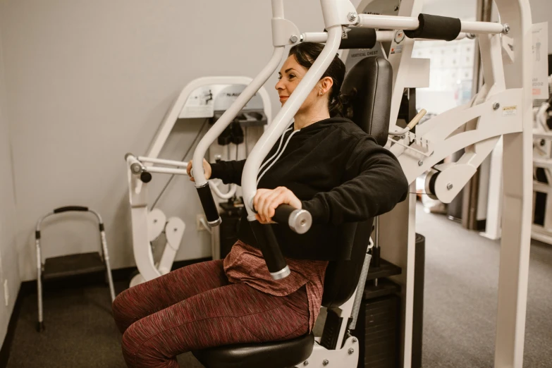 a woman sitting on the ground in an exercise gym