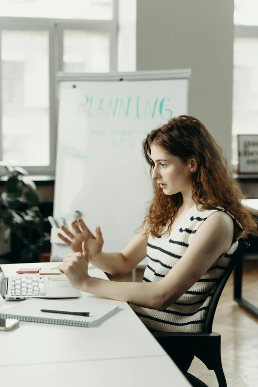 a woman sitting in front of a laptop computer