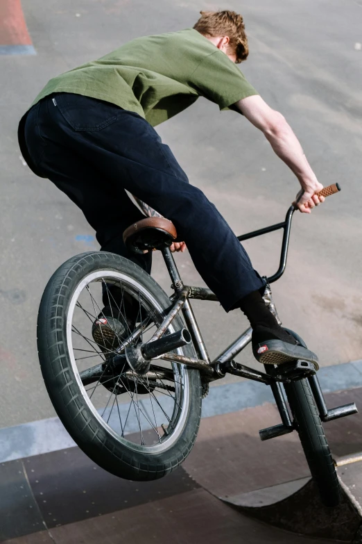 a man riding a skateboard on the handlebars of a bike