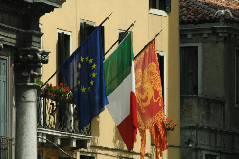 a row of flags on the side of a building