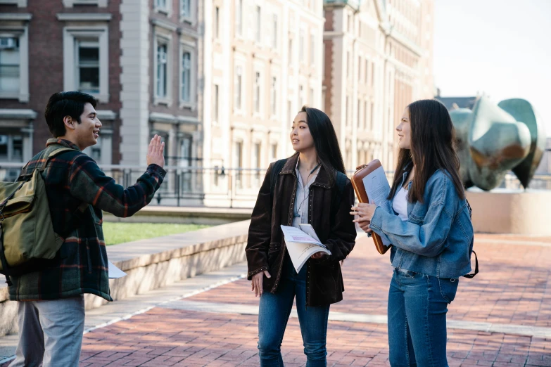 there is a woman and two girls talking on the sidewalk