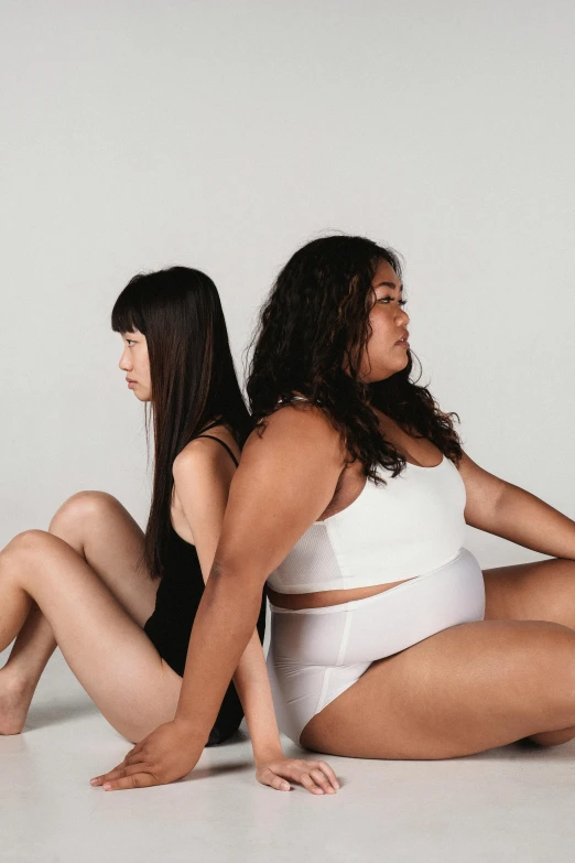 two woman are posing in their underwear