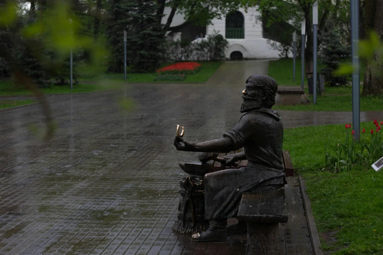 a statue is seated on a motorcycle with a house in the background