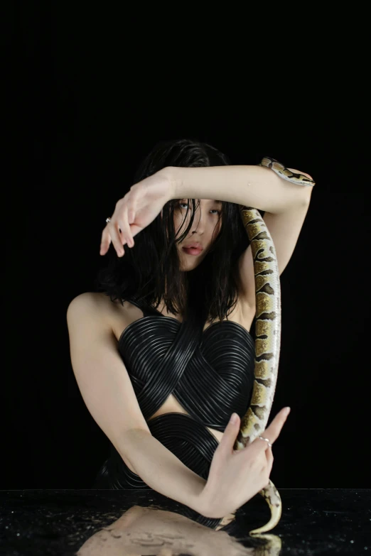 a woman holding a large snake on top of her arm