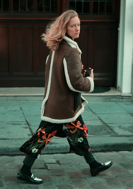 a girl with blonde hair walking down a city street