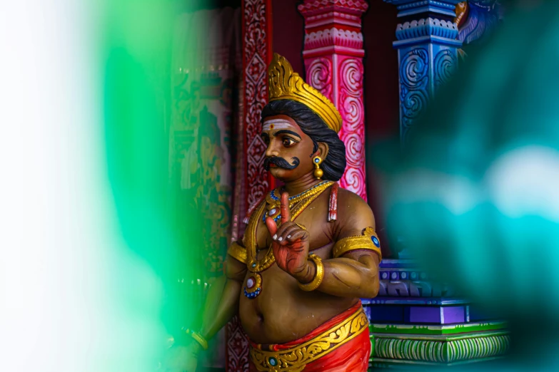 a statue with multiple colors around it sitting on the ground