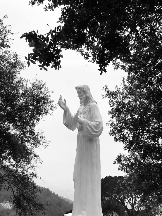 a statue of jesus with a robe and holding hands up