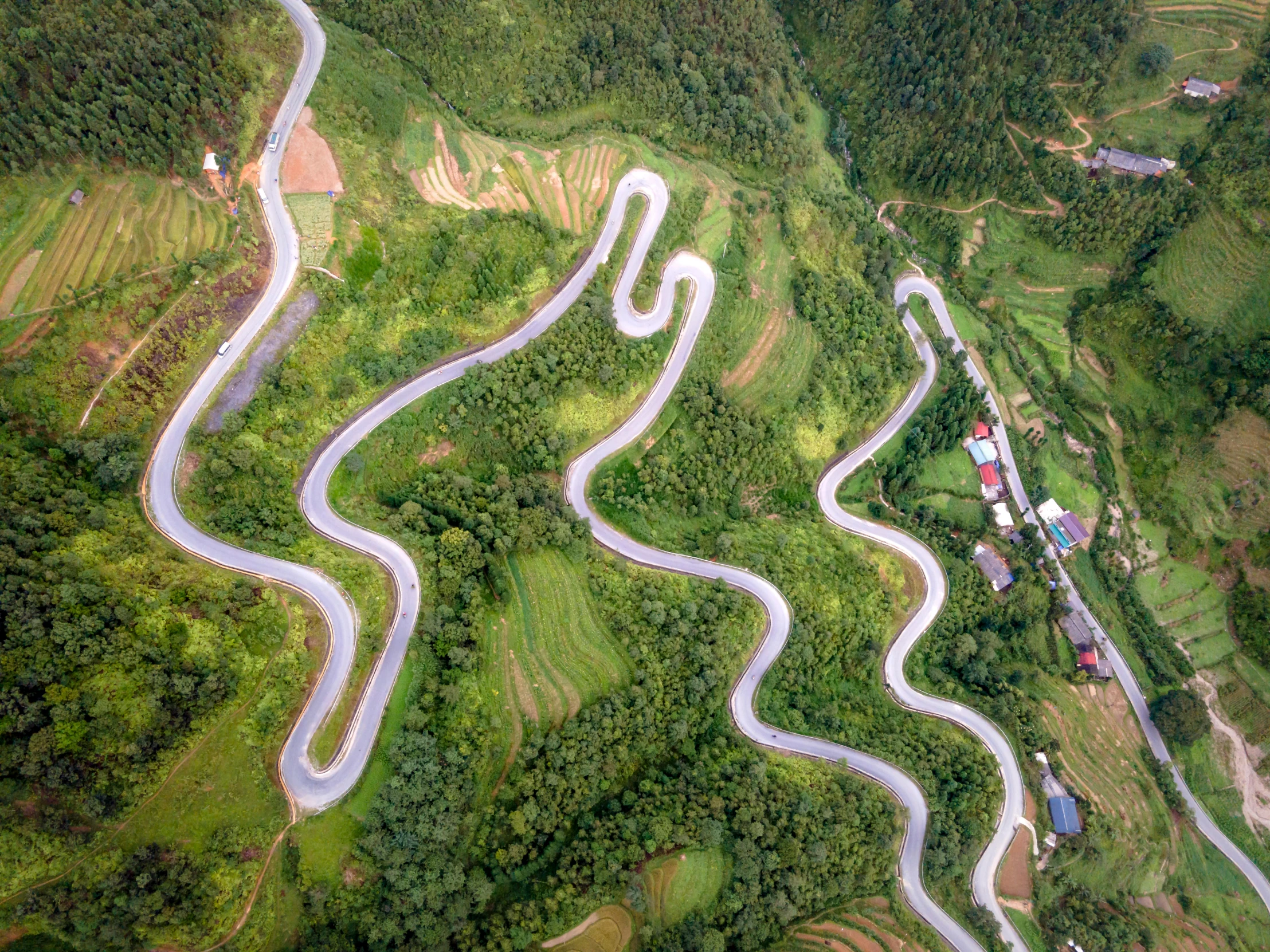 an aerial view shows several winding roads with trees in the background