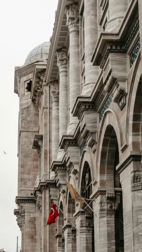 a few building made of stone with multiple flags