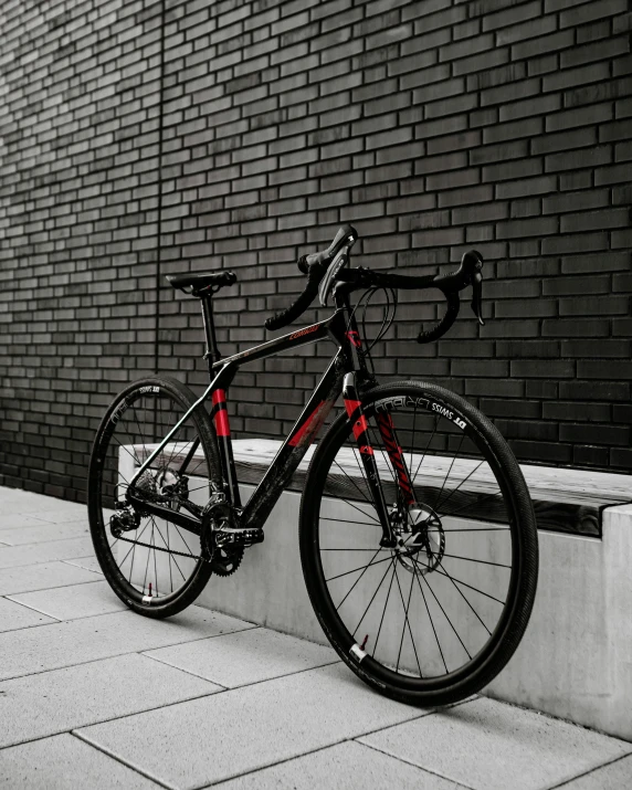 a bike parked against a brick wall next to the side walk