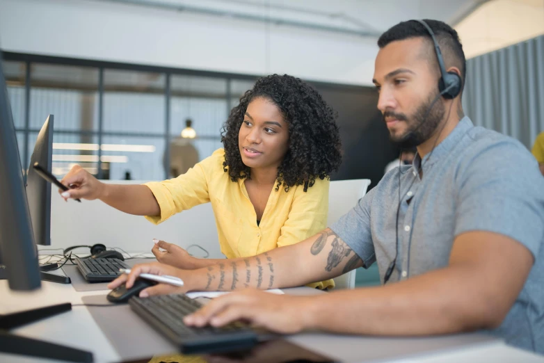 man and woman sitting in front of computer