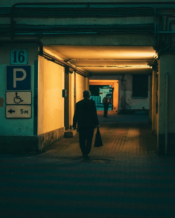a person walking down a hallway near a parking meter