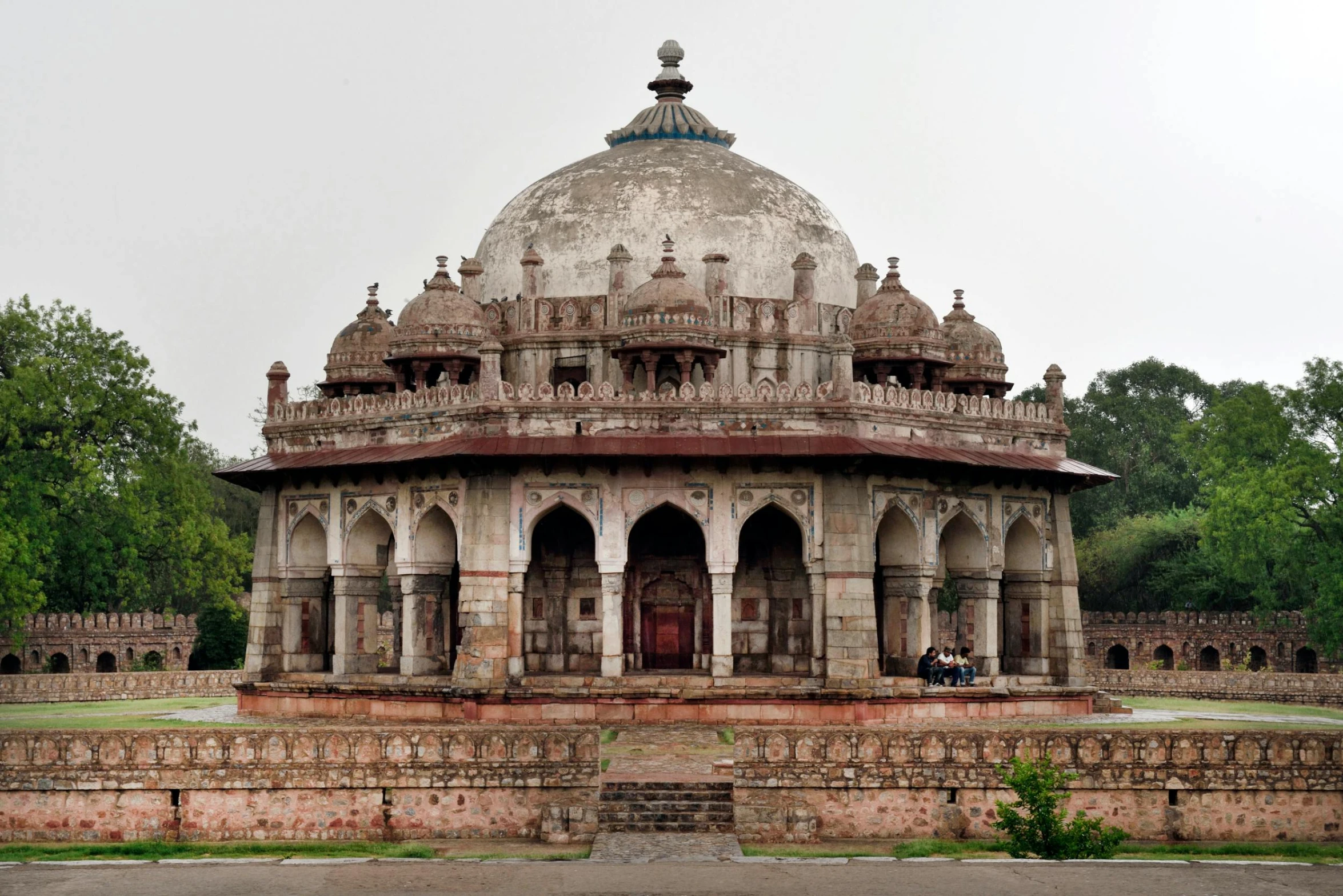 a white and tan circular structure surrounded by green grass