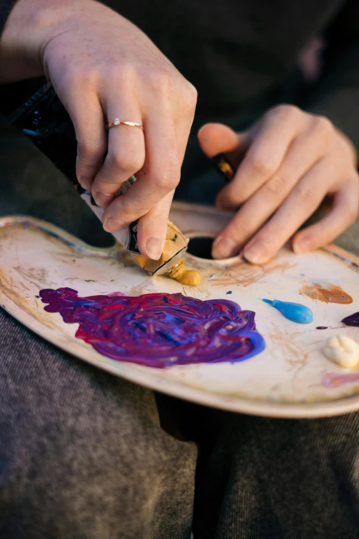 someone holding a piece of paper with various paint shapes on it