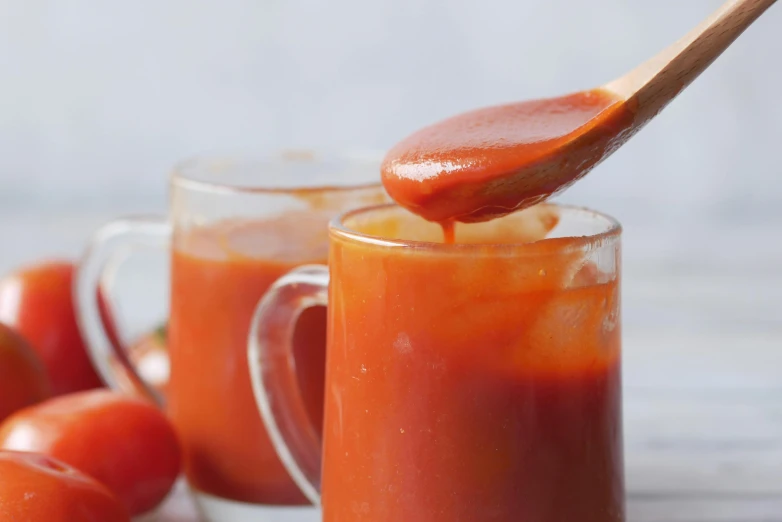 a wooden spoon pouring juice on carrots