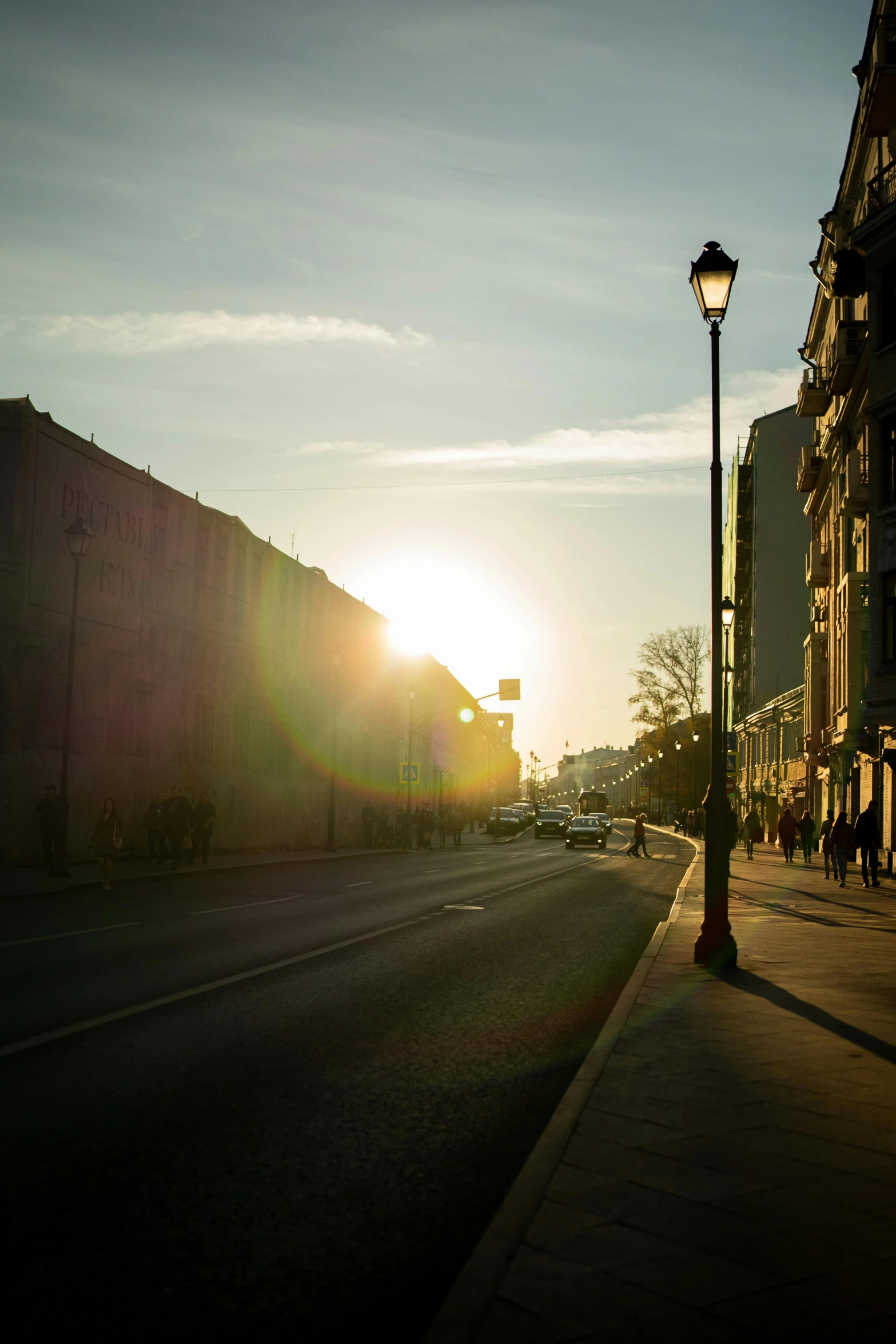 the sun is setting in a city street