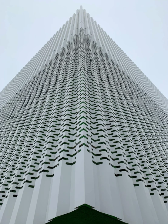 the side of a tall building that is in a very cloudy sky