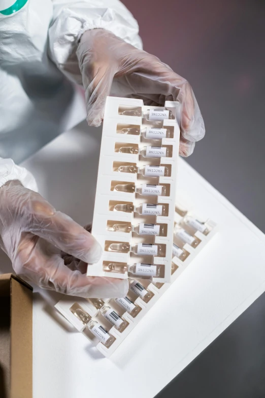 person in a lab coat holding out a keyboard