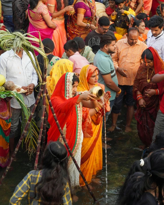 several people in colorful attire are gathering around water