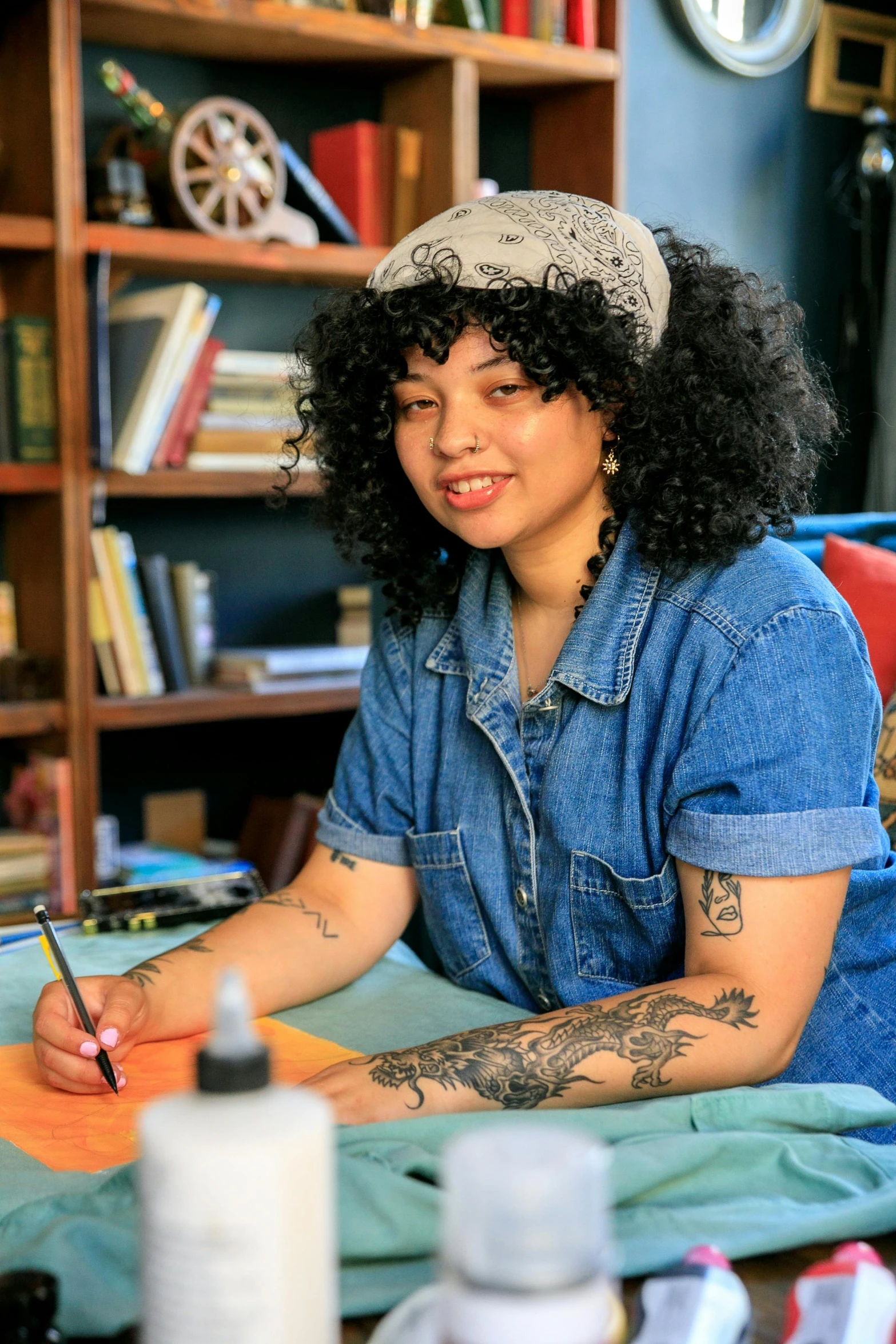 a young woman writing on an open book in a room