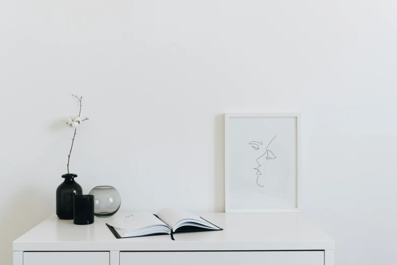 a white dresser and two vases on top of it