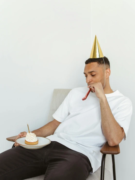 a man sitting on top of a chair with a piece of cake