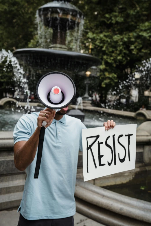 a protester holding up a sign saying resist