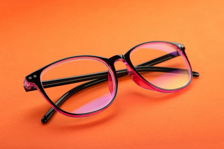 a pair of glasses sitting on an orange background
